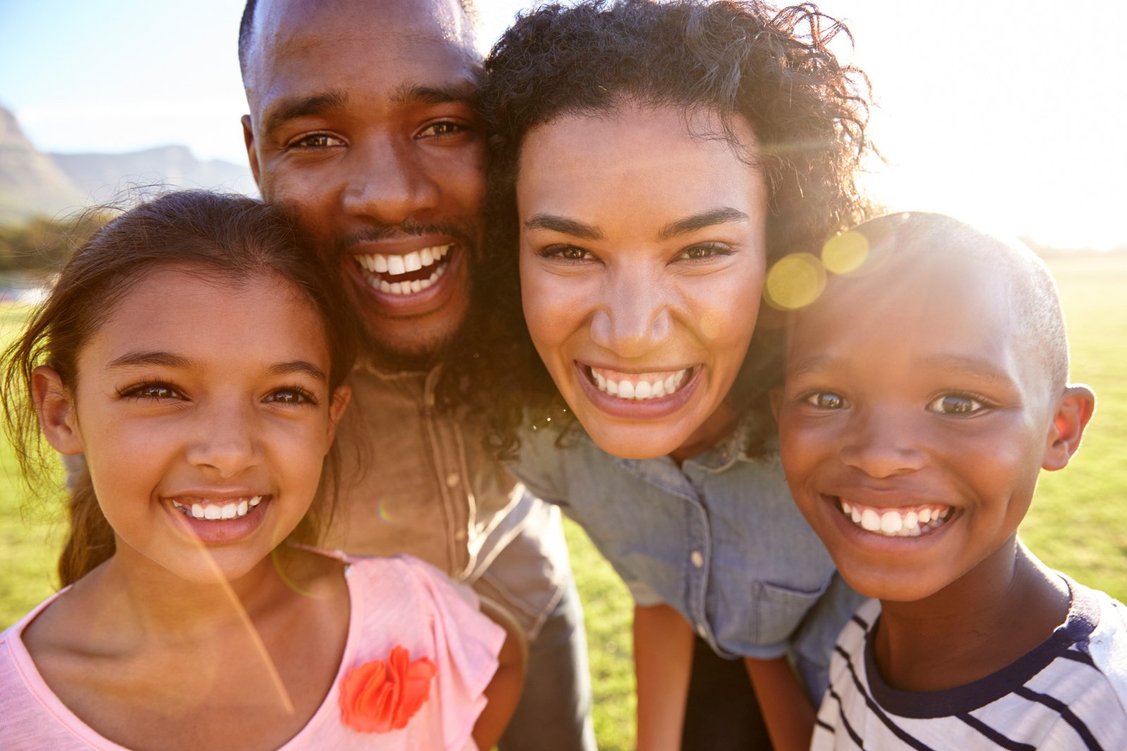 laughing-black-family-outdoors-close-up-back-lit-PPCMZD4.jpg